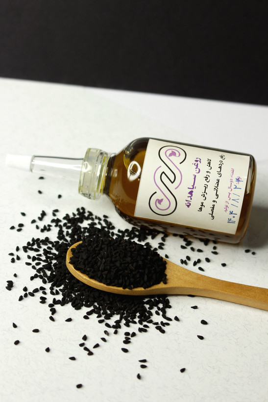 عکس روغن سیاهدانه خالص در کنار دانههای سیاهدانه برای مراقبت مو